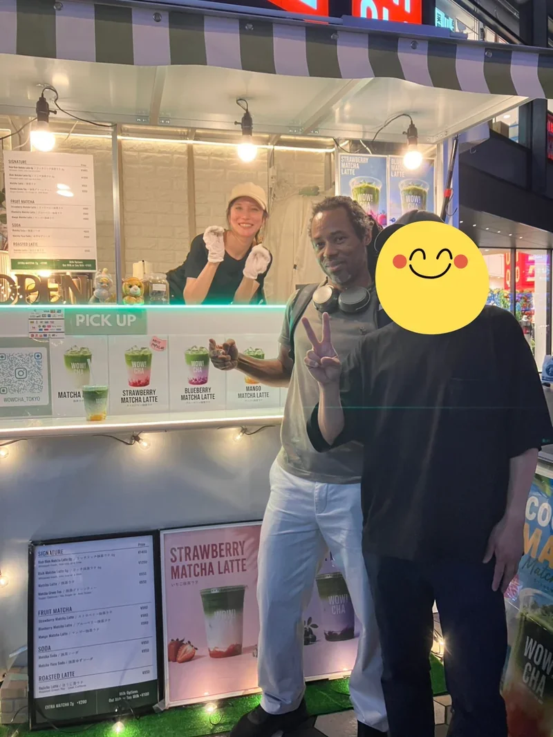 Tourists giving peace sign with matcha drinks at WOW!CHA kitchen car, Asakusa Tokyo