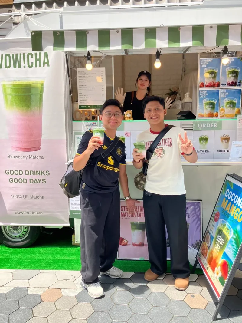 Tourists posing with matcha drinks at WOW!CHA kitchen car, Asakusa Tokyo