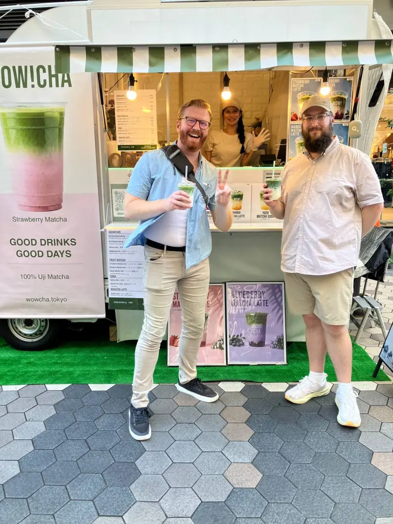 Two friends giving peace sign with matcha drinks at WOW!CHA kitchen car, Asakusa Tokyo