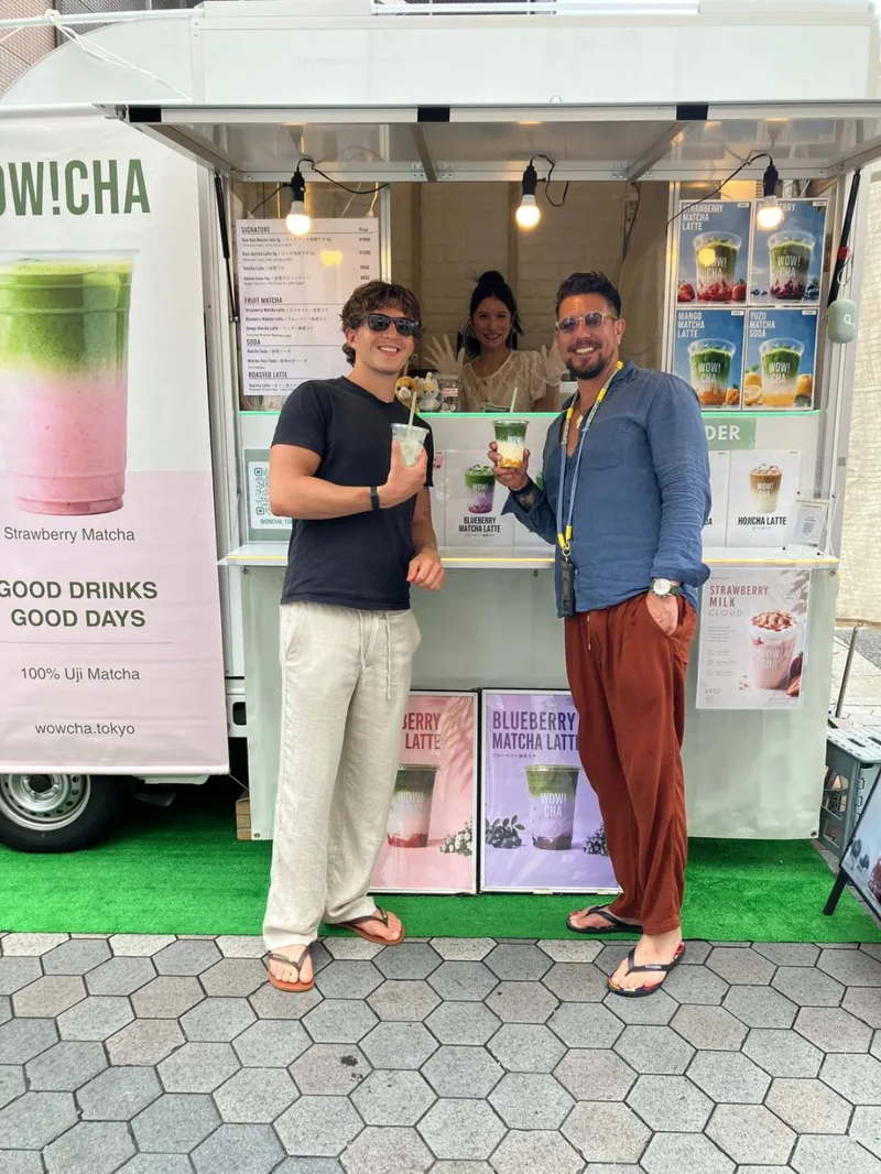 Two friends holding matcha drinks at WOW!CHA kitchen car, Asakusa Tokyo